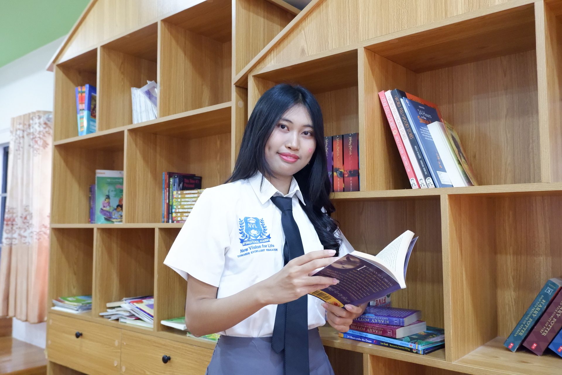 Student selecting and reading a library book